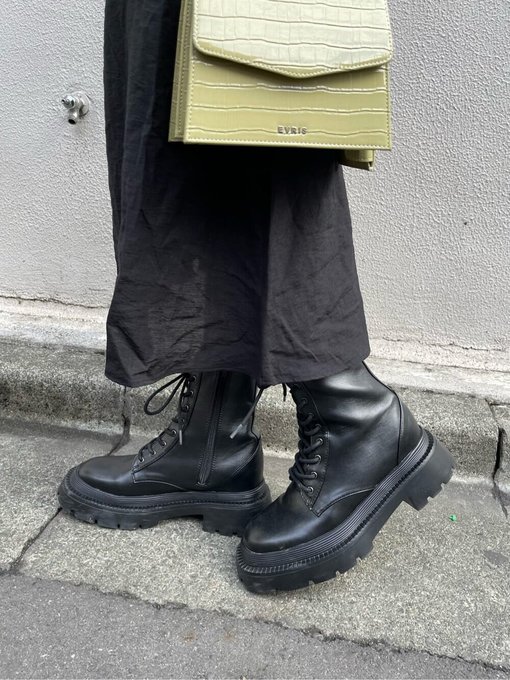 ブラック系のブーツ、グリーン系のショルダーバッグ、ブラック系のワンピースを着用したレディースの春コーディネートの9枚目の写真