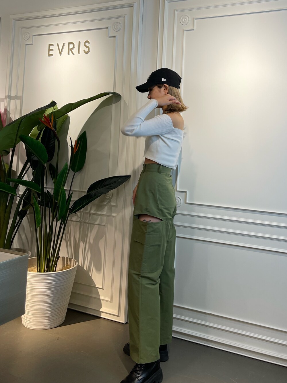 グリーン系のニット/セーター、ブラック系のブーツ、ベージュ系のカーゴパンツを着用したレディースの春コーディネートの3枚目の写真