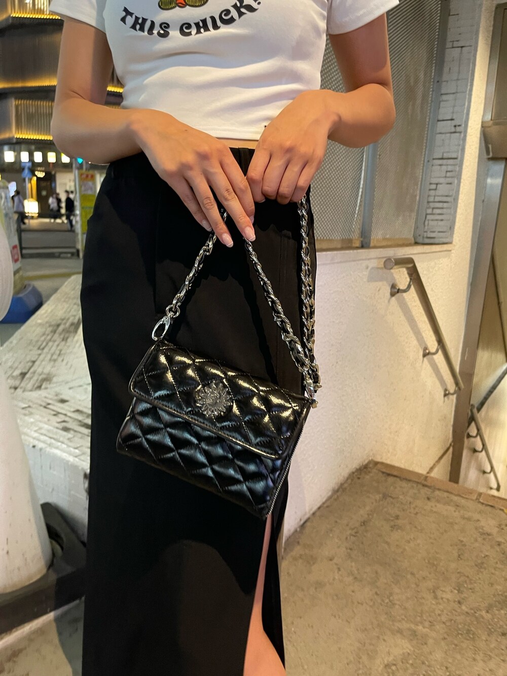 ホワイト系のTシャツ/カットソー、ブラック系のスカート、ブラック系のショルダーバッグを着用したレディースの夏コーディネートの7枚目の写真