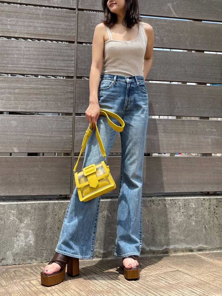 ブルー系のデニムパンツ、ブラウン系のサンダル、ホワイト系のTシャツ/カットソーを着用したレディースの夏コーディネートの3枚目の写真