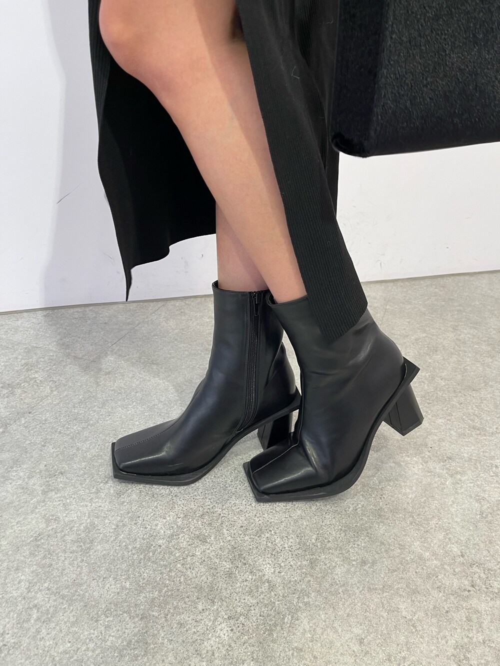 ブラック系のブーツ、ブラック系のショルダーバッグ、ブラック系のワンピースを着用したレディースの冬コーディネートの7枚目の写真