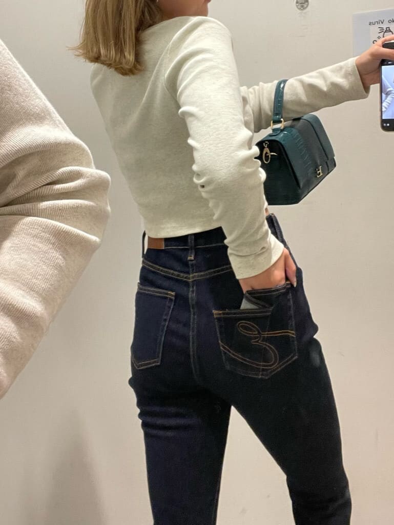 ブルー系のデニムパンツ、グレー系のTシャツ/カットソー、ホワイト系のスニーカーを着用したレディースの秋コーディネートの4枚目の写真