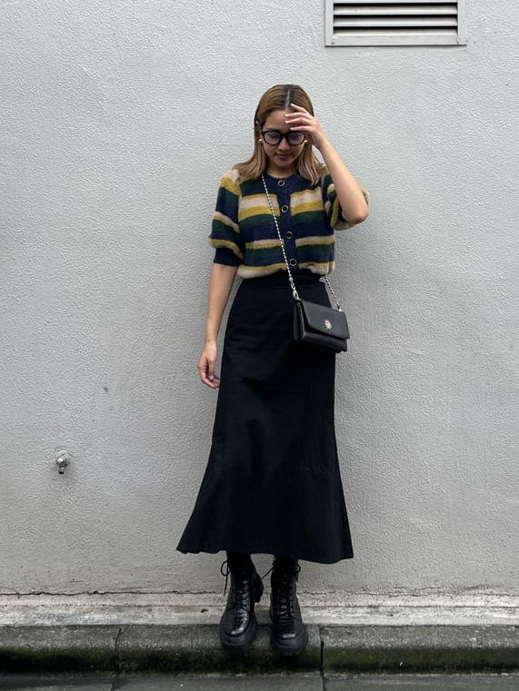 ブラック系のスカート、その他のブーツ、ブラック系のショルダーバッグを着用したレディースの秋コーディネートの2枚目の写真
