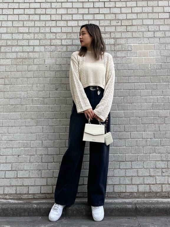 ブラック系のデニムパンツ、ホワイト系のキャミソール、ホワイト系のショルダーバッグを着用したレディースの春コーディネートの2枚目の写真