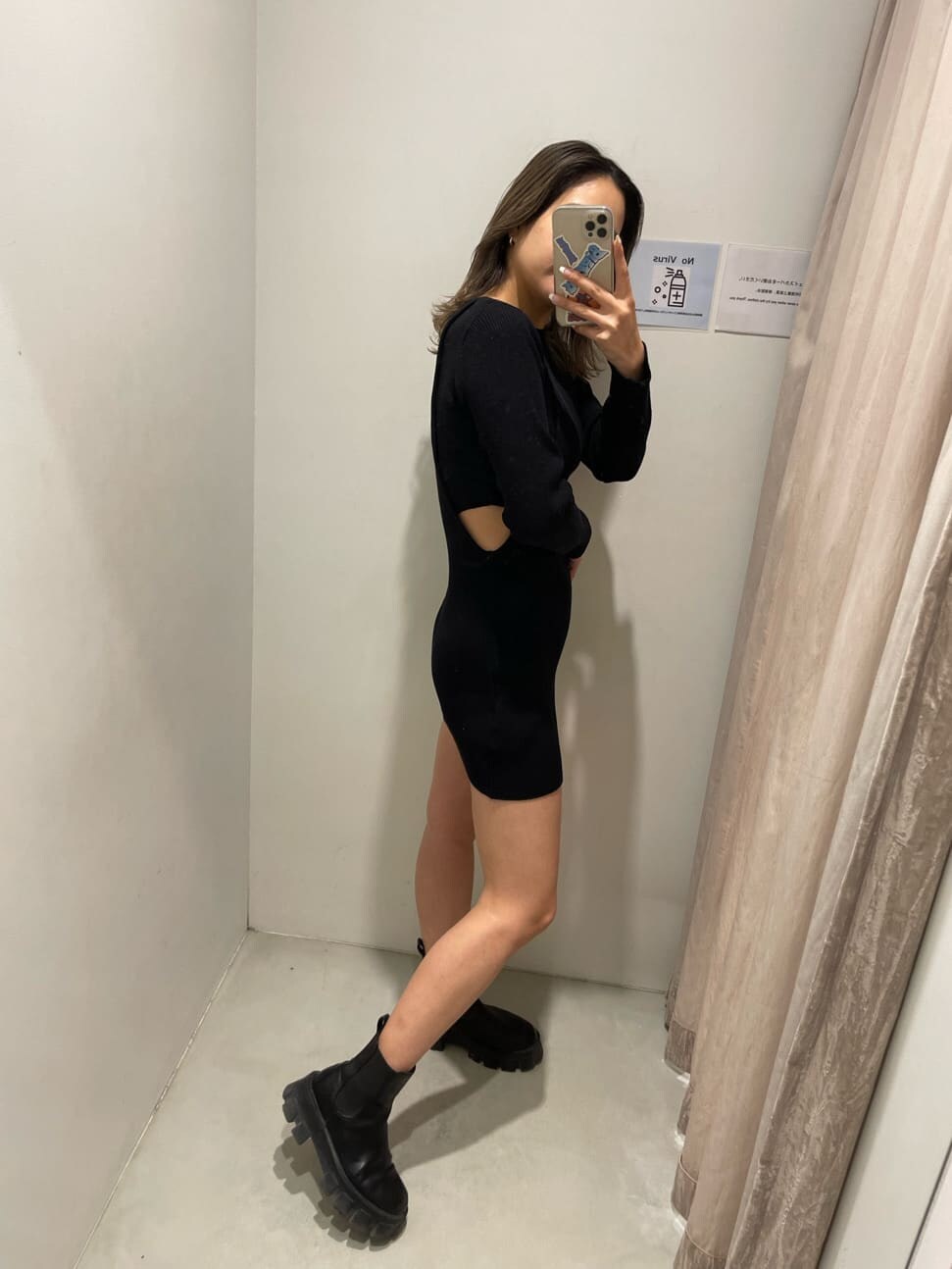 ブラック系のワンピース、ブラック系のブーツ、ホワイト系のブルゾンを着用したレディースの冬コーディネートの4枚目の写真