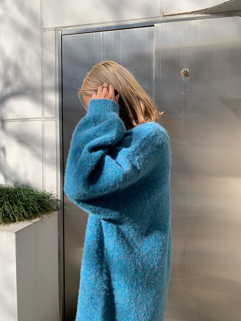 ブラック系のハンドバッグ、ブルー系のカーディガン/ボレロ、ホワイト系のTシャツ/カットソーを着用したレディースの冬コーディネートの6枚目の写真