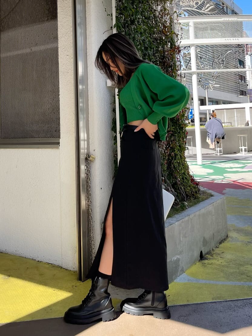 ブラック系のカーディガン/ボレロ、ブラック系のブーツ、ホワイト系のショルダーバッグを着用したレディースの春コーディネートの3枚目の写真