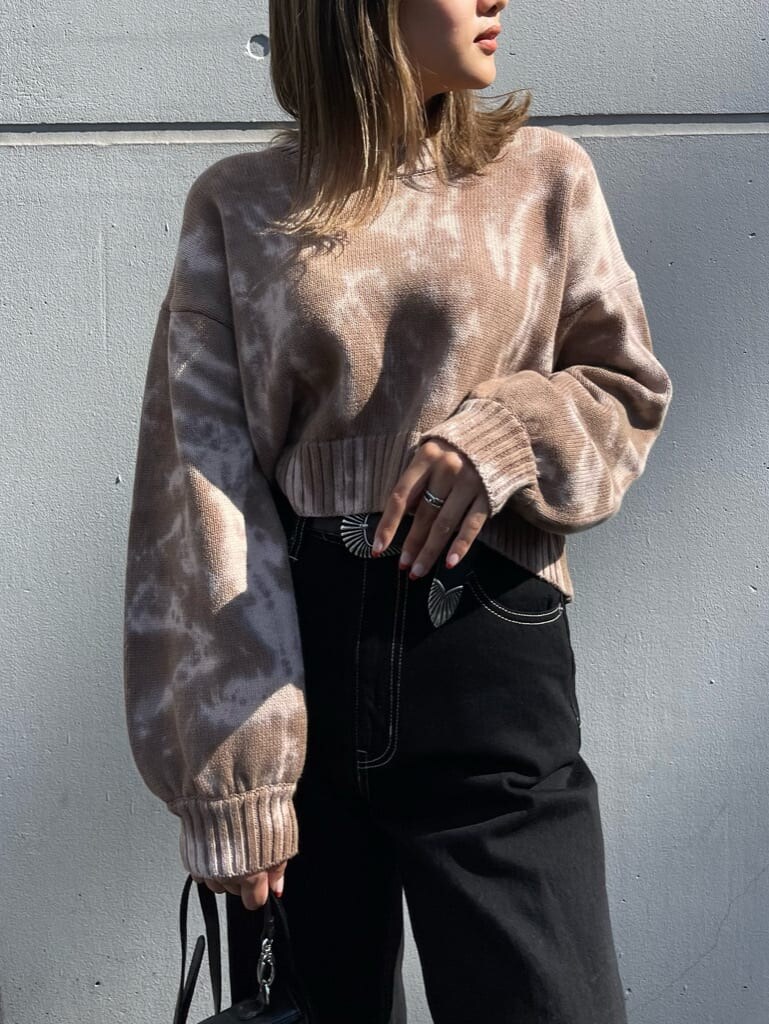 ブラック系のブーツ、ベージュ系のニット/セーター、ブラック系のデニムパンツを着用したレディースの秋コーディネートの4枚目の写真