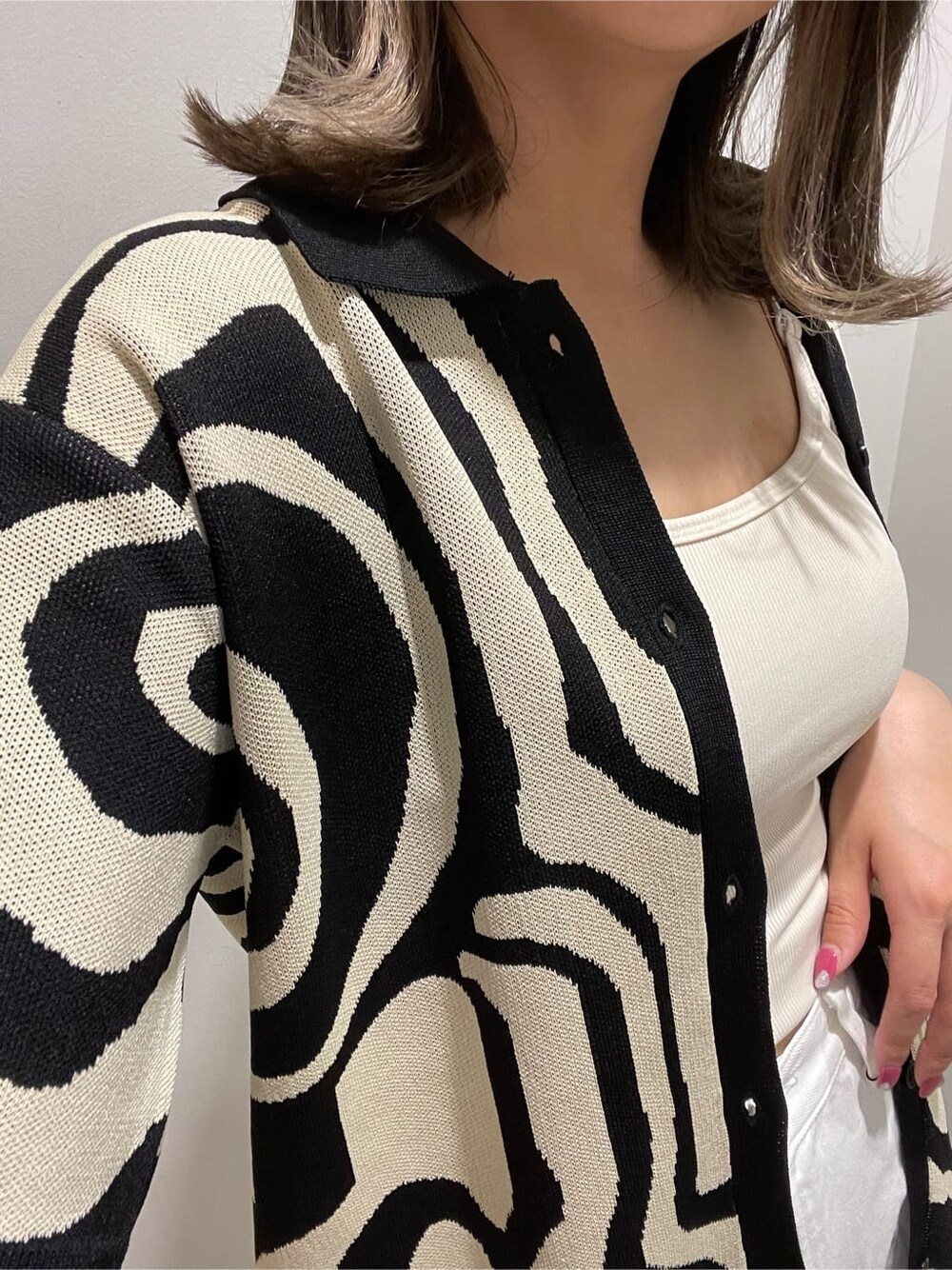 ホワイト系のキャミソール、ホワイト系のデニムパンツ、ブラック系のニット/セーターを着用したレディースの春コーディネートの7枚目の写真