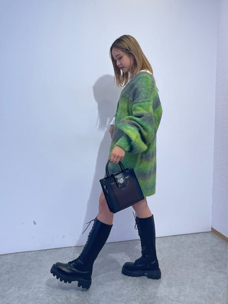 ブラック系のブーツ、ブラック系のショルダーバッグ、グリーン系のカーディガン/ボレロを着用したレディースの秋コーディネートの2枚目の写真