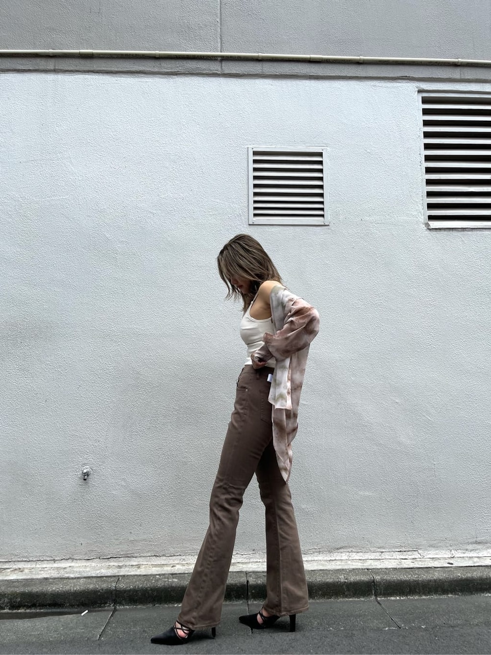 ブラウン系のシャツ/ブラウス、ブラック系のサンダル、ブラウン系のデニムパンツを着用したレディースの夏コーディネートの2枚目の写真