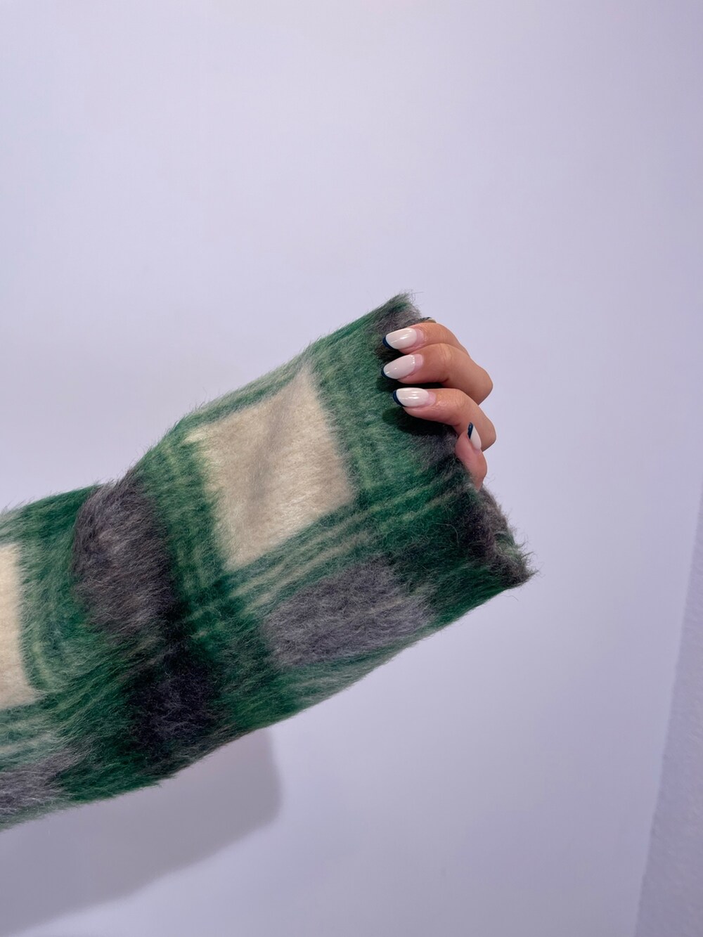 グリーン系のその他アウター、ブラック系のブーツ、ブラック系のワンピースを着用したレディースの冬コーディネートの9枚目の写真