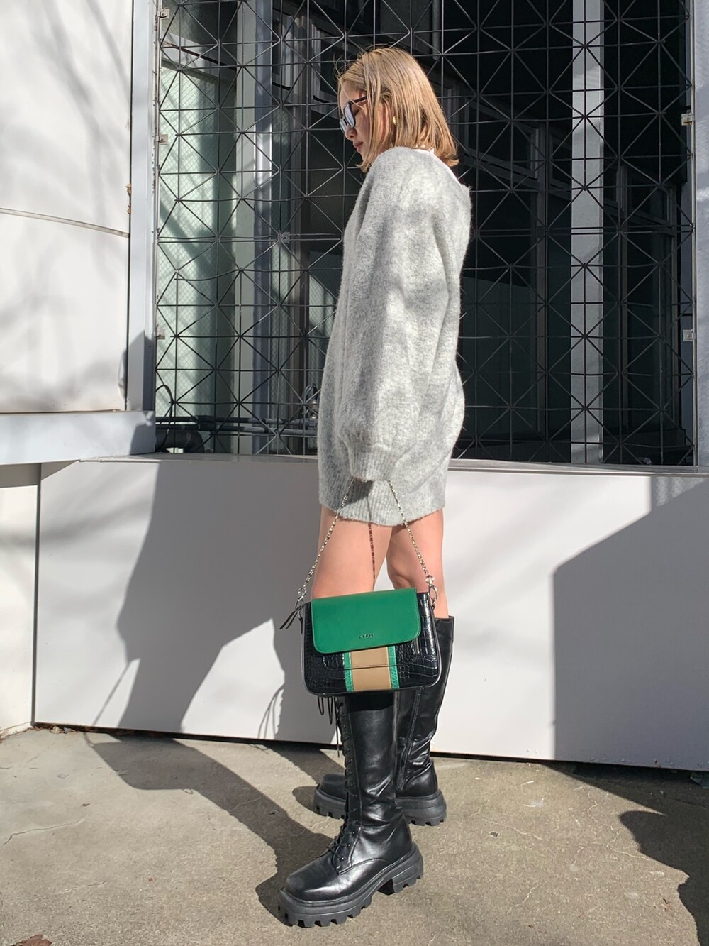 グレー系のカーディガン/ボレロ、ブラック系のブーツ、ホワイト系のTシャツ/カットソーを着用したレディースの冬コーディネートの3枚目の写真