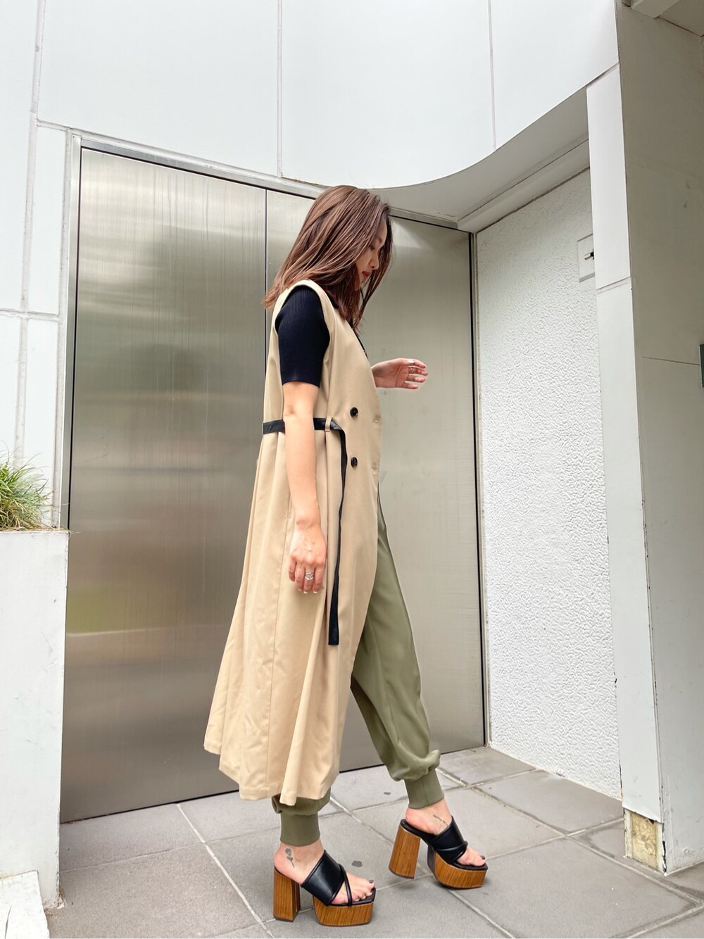 ベージュ系のその他パンツ、ベージュ系のトレンチコート、ブラック系のサンダルを着用したレディースの春コーディネートの3枚目の写真