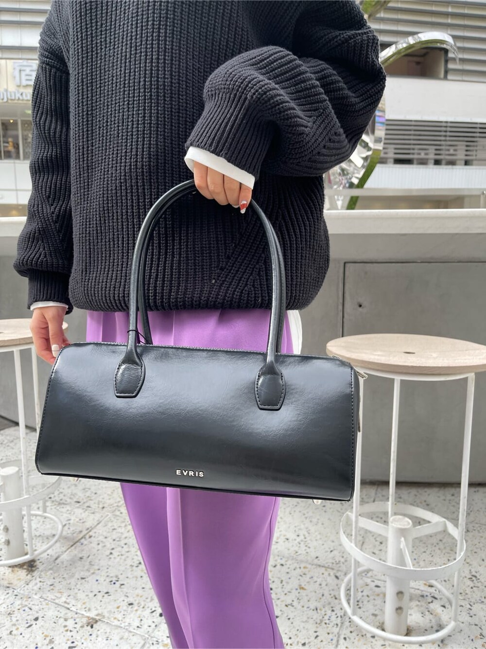 ブラック系のボストンバッグ、ホワイト系のシャツ/ブラウス、ブラック系のニット/セーターを着用したレディースの冬コーディネートの7枚目の写真