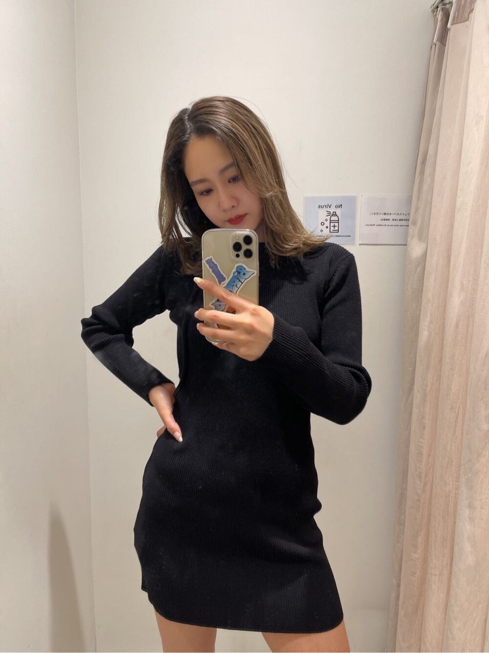 ブラック系のワンピース、ブラック系のブーツ、ホワイト系のブルゾンを着用したレディースの冬コーディネートの5枚目の写真