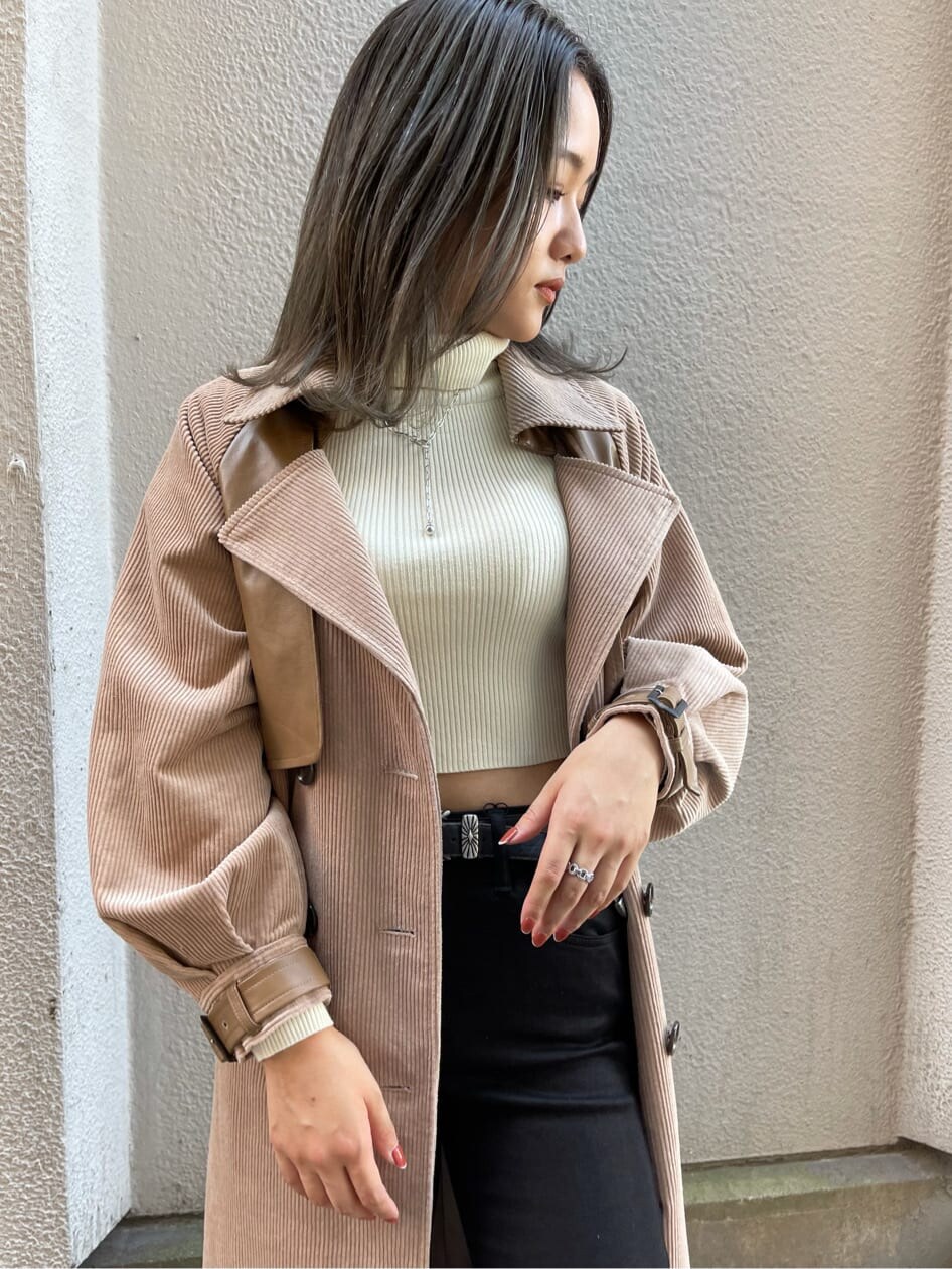 ブラック系のデニムパンツ、ベージュ系のトレンチコート、ホワイト系のニット/セーターを着用したレディースの秋コーディネートの5枚目の写真