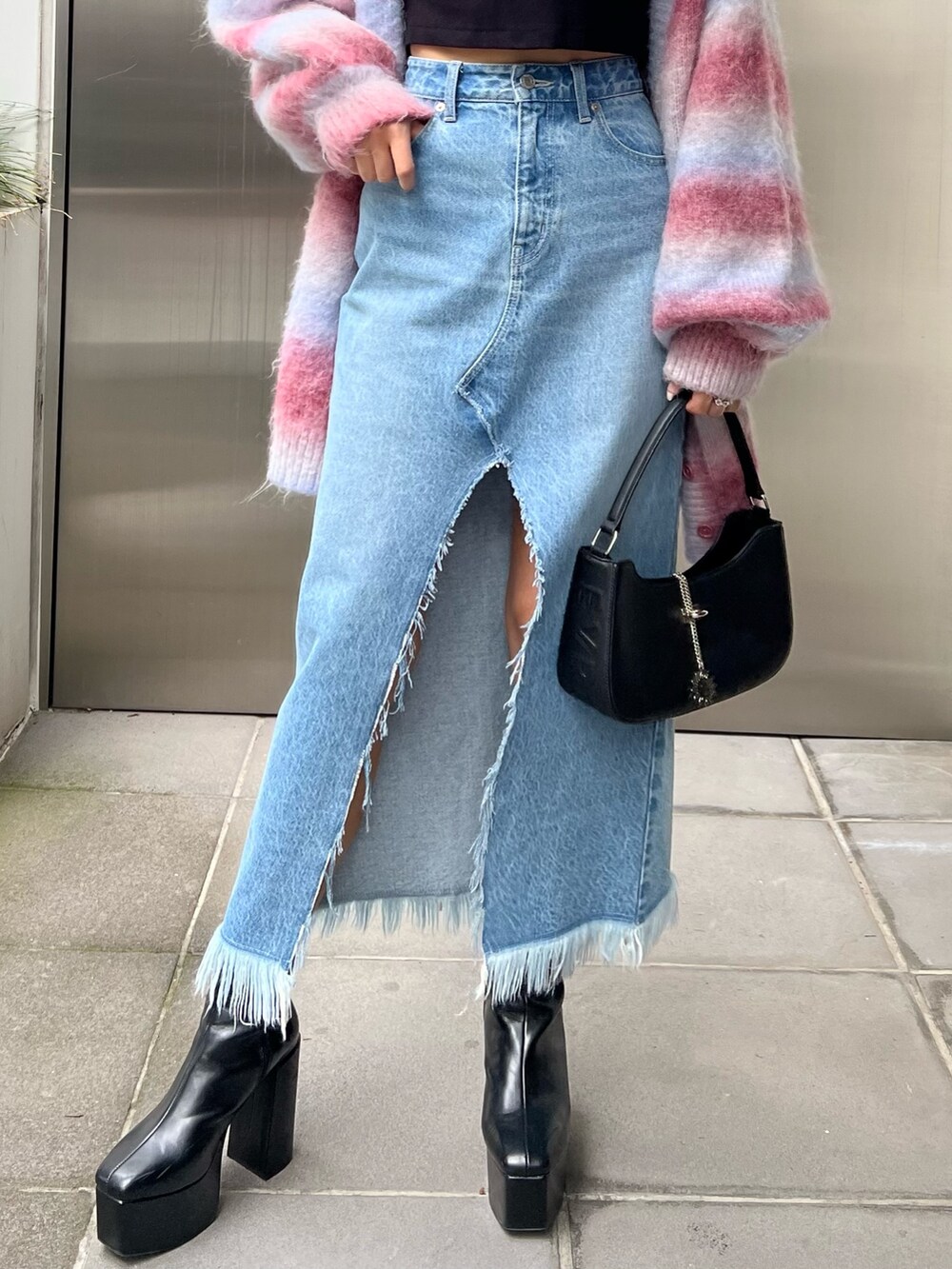 ブラック系のTシャツ/カットソー、ブルー系のデニムスカート、ピンク系のカーディガン/ボレロを着用したレディースの秋コーディネートの4枚目の写真