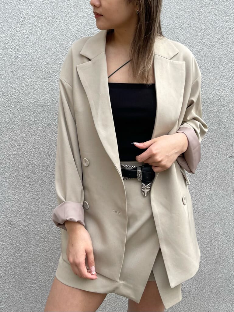 ブラック系のブーツ、ブラック系のキャミソール、ベージュ系のスカートを着用したレディースの春コーディネートの6枚目の写真