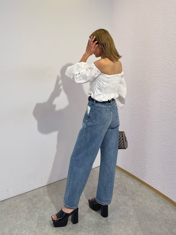 ブラック系のサンダル、ブラック系のボストンバッグ、ブルー系のデニムパンツを着用したレディースの夏コーディネートの3枚目の写真