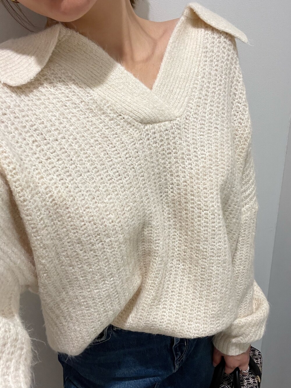 ブルー系のデニムスカート、ホワイト系のニット/セーター、ブラック系のブーツを着用したレディースの秋コーディネートの6枚目の写真