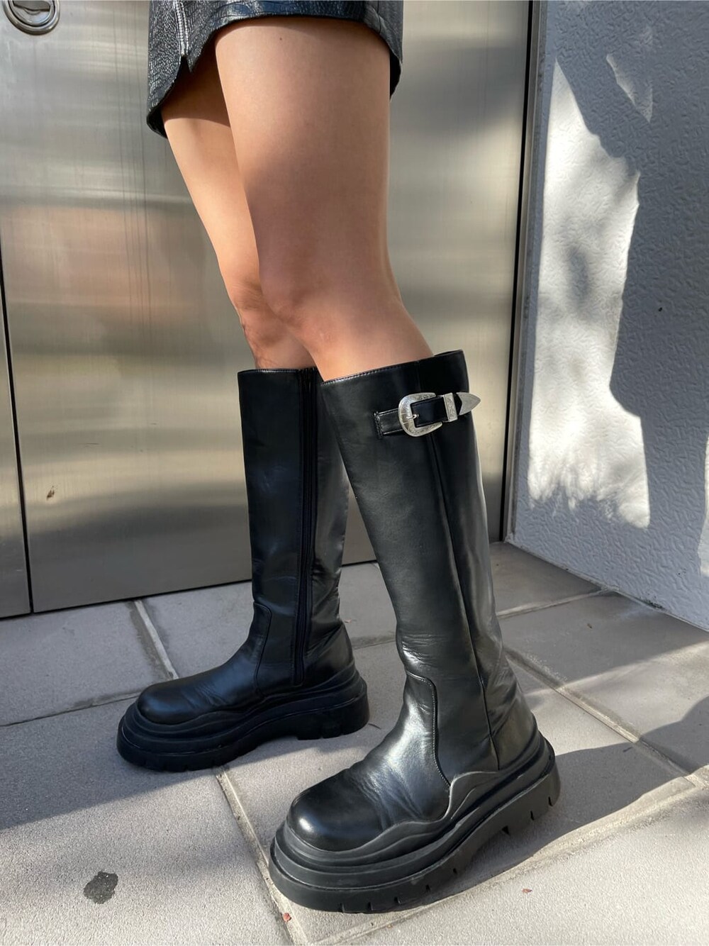 ブラック系のその他アウター、ブラック系のスカート、ブラック系のブーツを着用したレディースの秋コーディネートの7枚目の写真