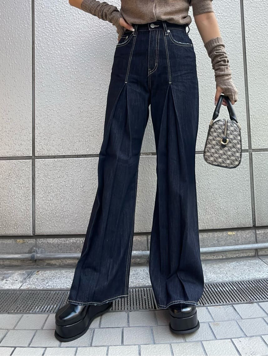 ブラック系のスリッポン、ブラック系のボストンバッグ、ブルー系のデニムパンツを着用したレディースの夏コーディネートの5枚目の写真