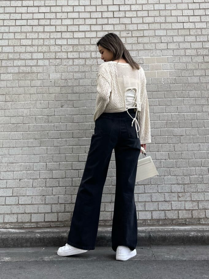 ブラック系のデニムパンツ、ホワイト系のキャミソール、ホワイト系のショルダーバッグを着用したレディースの春コーディネートの3枚目の写真