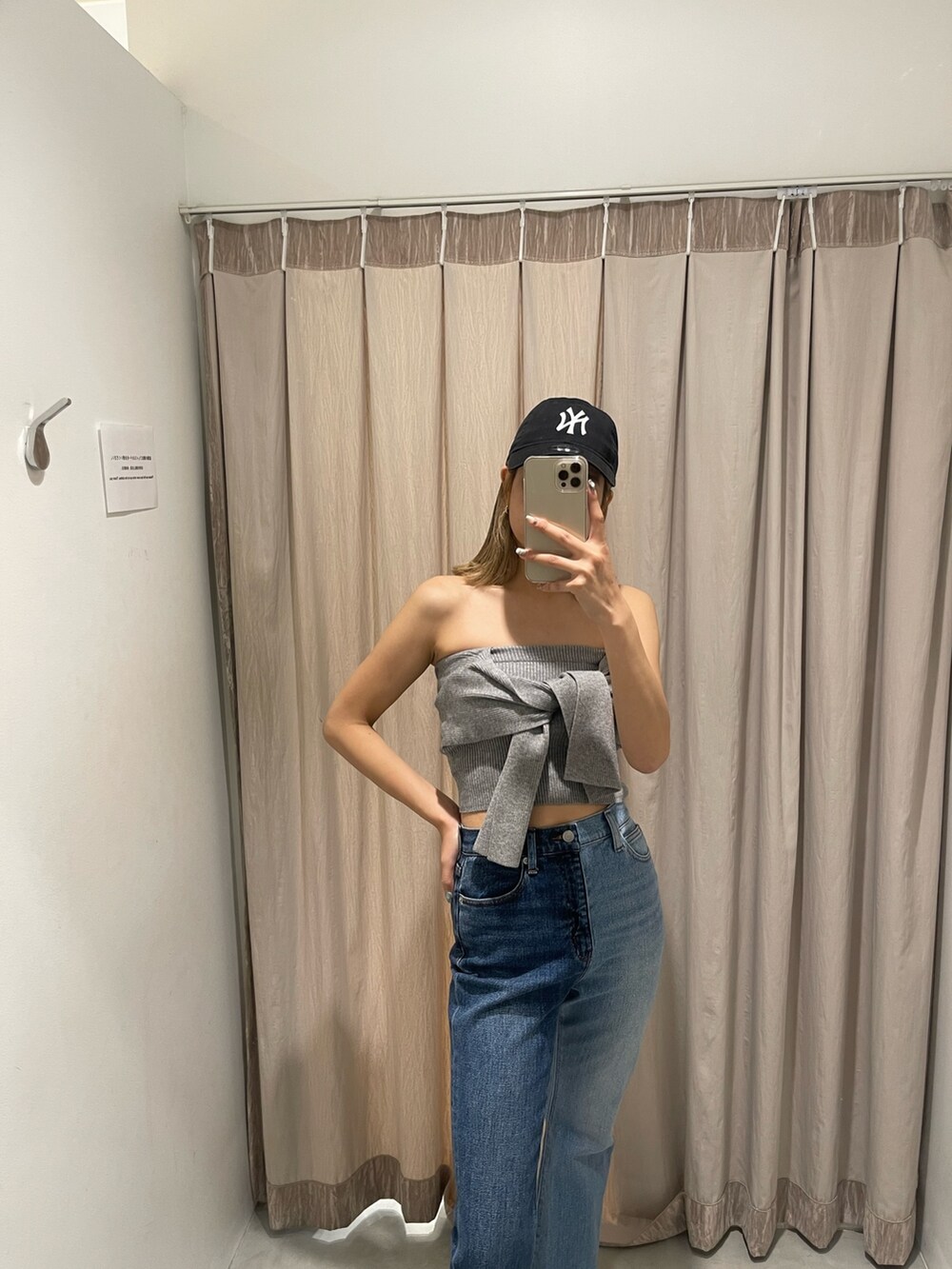 ブラック系のサンダル、グレー系のチューブトップ、ブルー系のデニムパンツを着用したレディースの春コーディネートの6枚目の写真