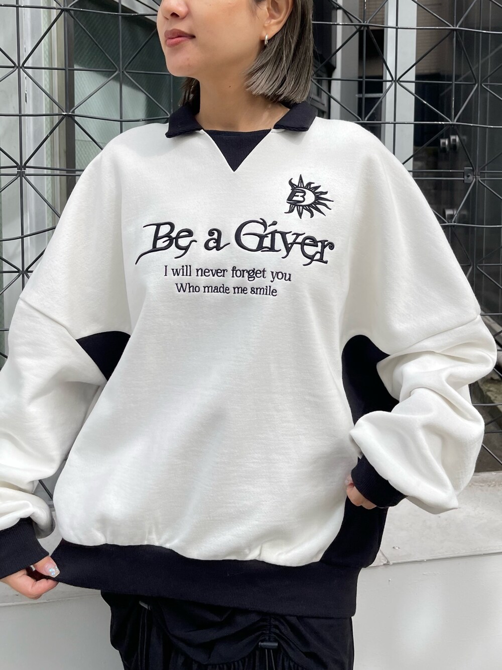 ホワイト系のスウェット、ブラック系のスカート、ブラック系のブーツを着用したレディースの秋コーディネートの5枚目の写真