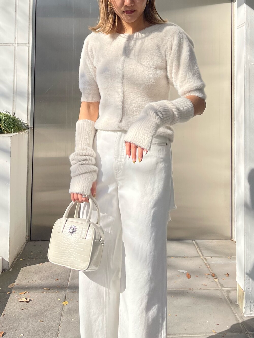 ホワイト系のショルダーバッグ、ホワイト系のサンダル、ホワイト系のニット/セーターを着用したレディースの冬コーディネートの4枚目の写真