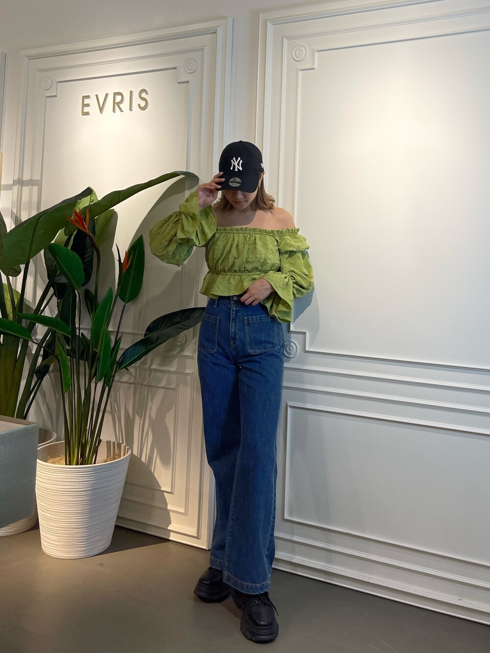 ブルー系のデニムパンツ、ブラック系のスニーカー、グリーン系のシャツ/ブラウスを着用したレディースの春コーディネートの4枚目の写真