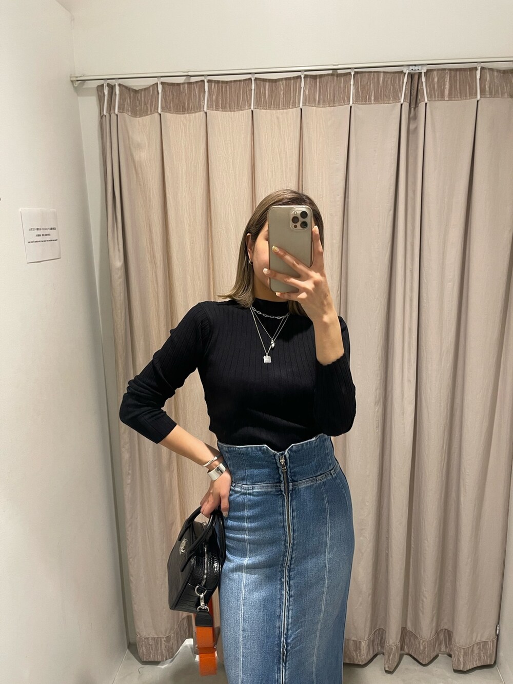 ブラック系のショルダーバッグ、ブラック系のブーツ、ブラック系のニット/セーターを着用したレディースの冬コーディネートの3枚目の写真