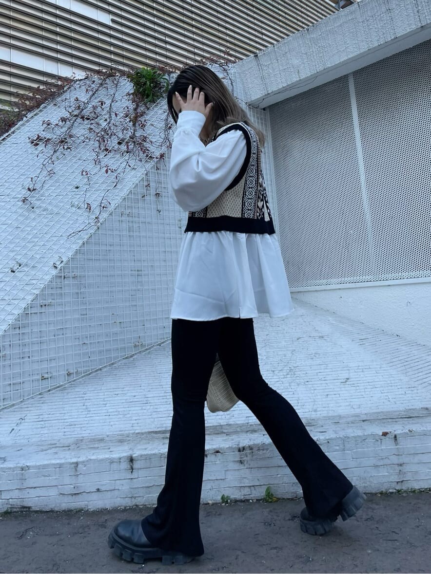 ブラック系のシャツ/ブラウス、ホワイト系のショルダーバッグ、ブラック系のブーツを着用したレディースの冬コーディネートの2枚目の写真