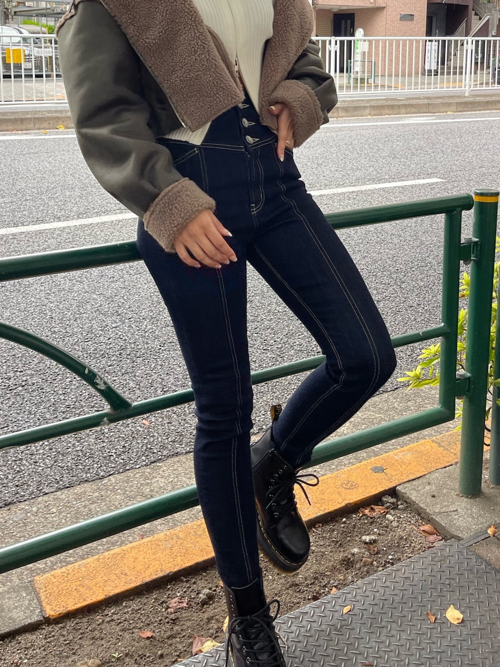 ブラック系のブーツ、ホワイト系のニット/セーター、グリーン系のブルゾンを着用したレディースの秋コーディネートの6枚目の写真