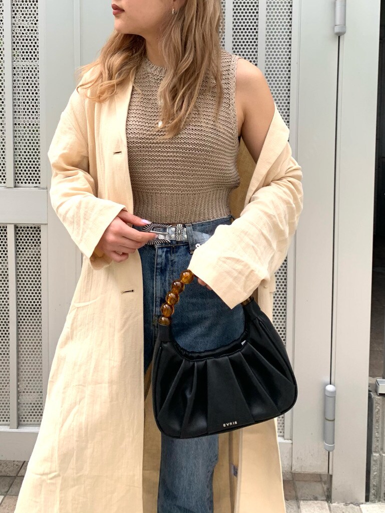 ブルー系のデニムパンツ、ブラック系のサンダル、ベージュ系のチェスターコートを着用したレディースの春コーディネートの9枚目の写真