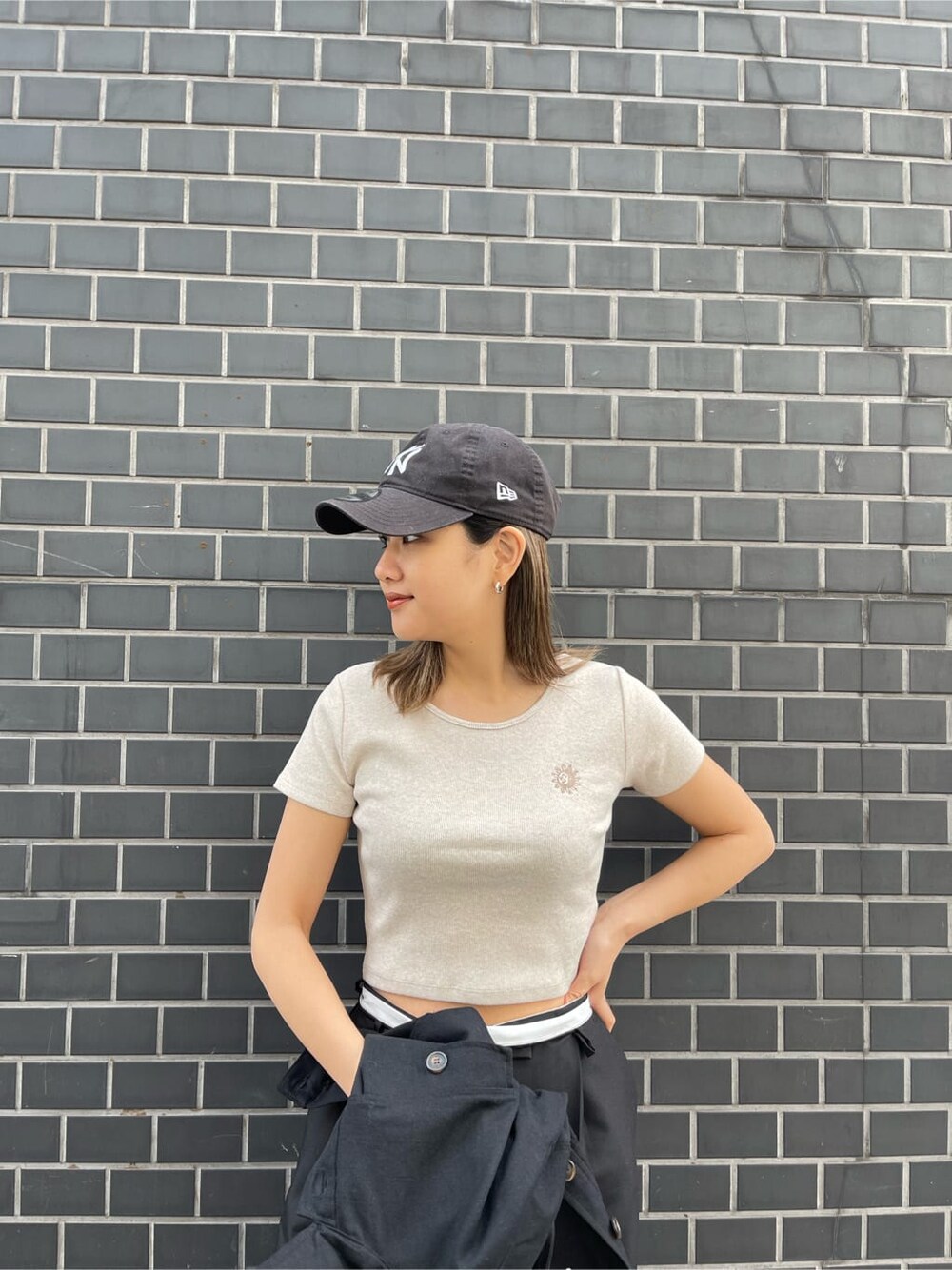 ブラック系のブルゾン、ホワイト系のショルダーバッグ、ベージュ系のTシャツ/カットソーを着用したレディースの春コーディネートの5枚目の写真