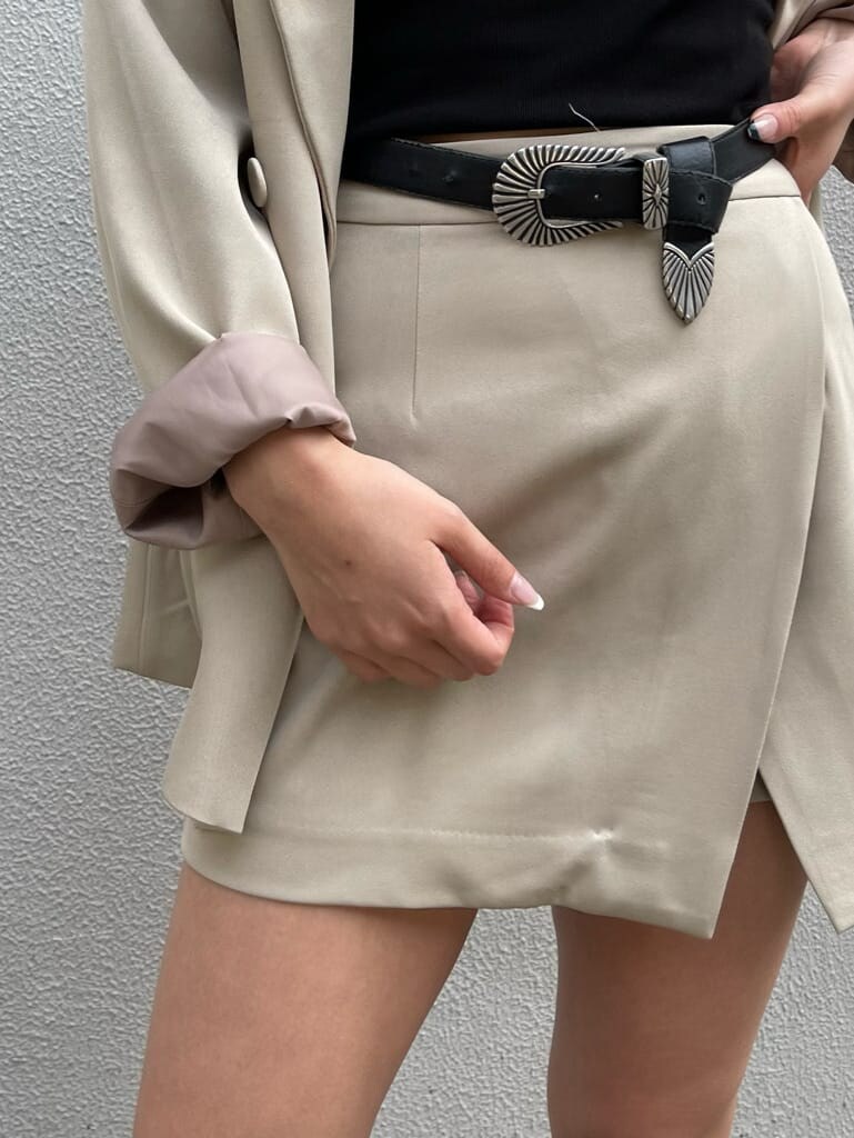 ブラック系のブーツ、ブラック系のキャミソール、ベージュ系のスカートを着用したレディースの春コーディネートの4枚目の写真