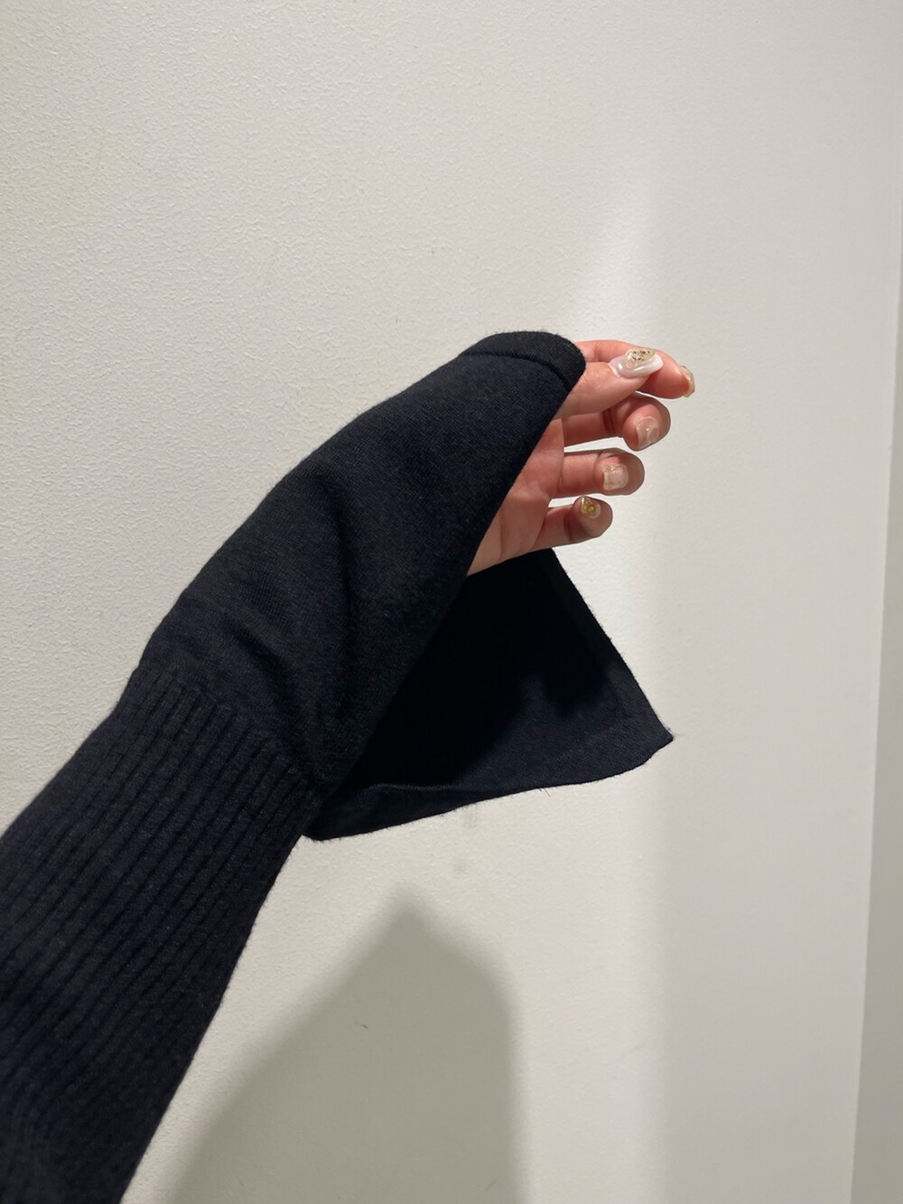 ホワイト系のブーツ、ブラック系のハンドバッグ、ブラック系のワンピースを着用したレディースの冬コーディネートの5枚目の写真