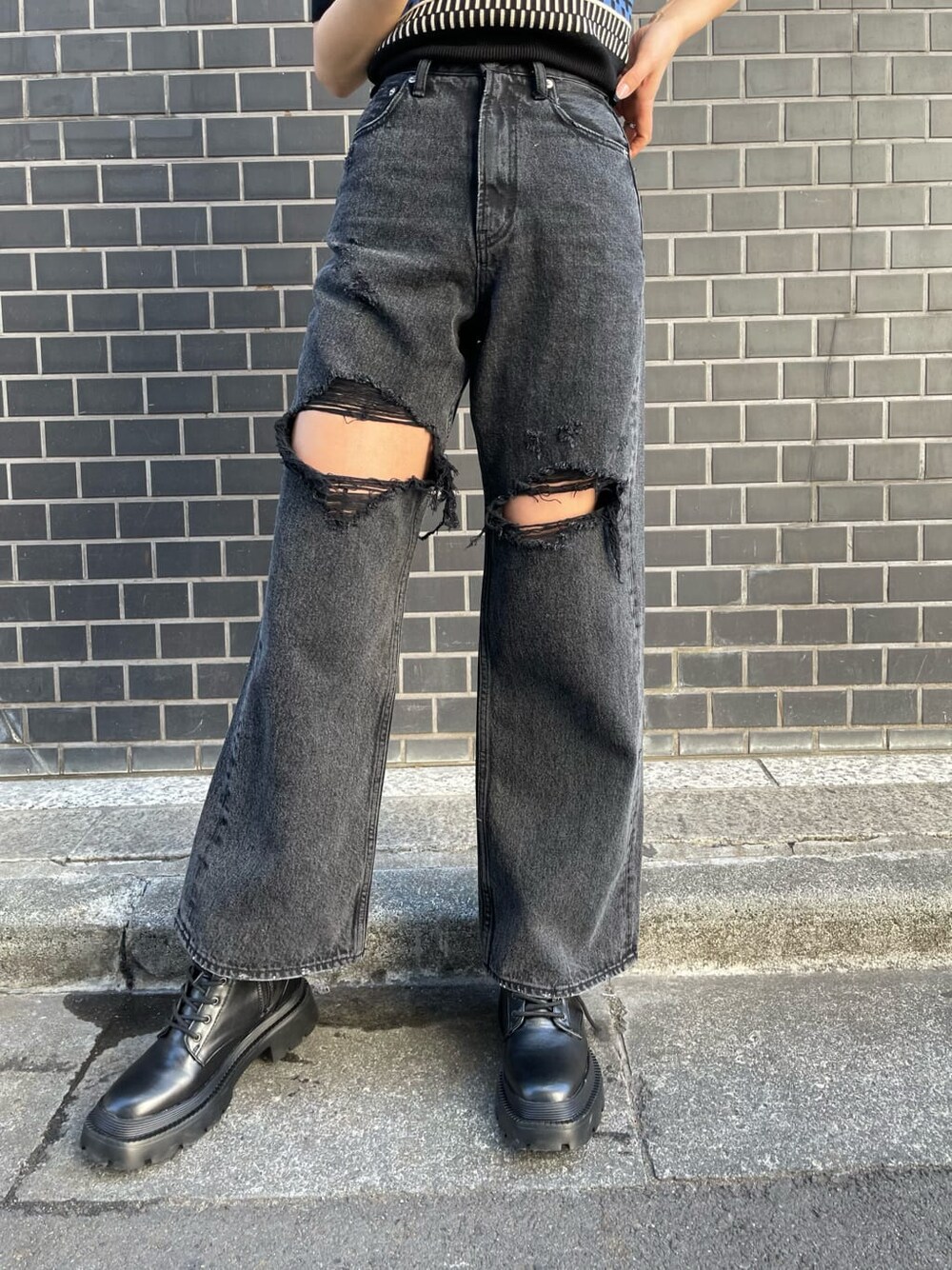 ブラック系のデニムパンツ、ブルー系のニット/セーター、ブラック系のブーツを着用したレディースの春コーディネートの7枚目の写真