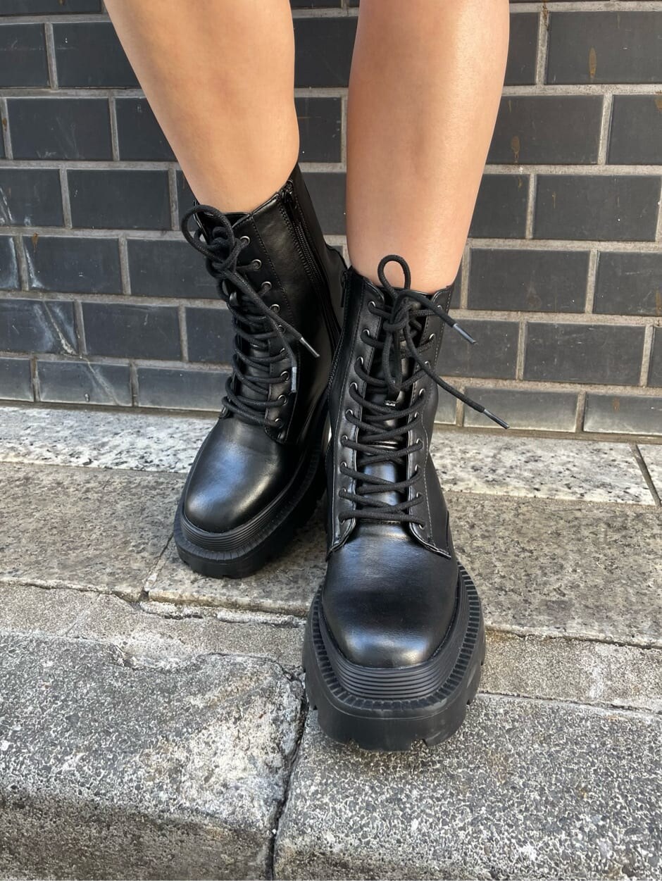 オレンジ系のワンピース、ブラック系のテーラードジャケット、ブラック系のブーツを着用したレディースの冬コーディネートの8枚目の写真