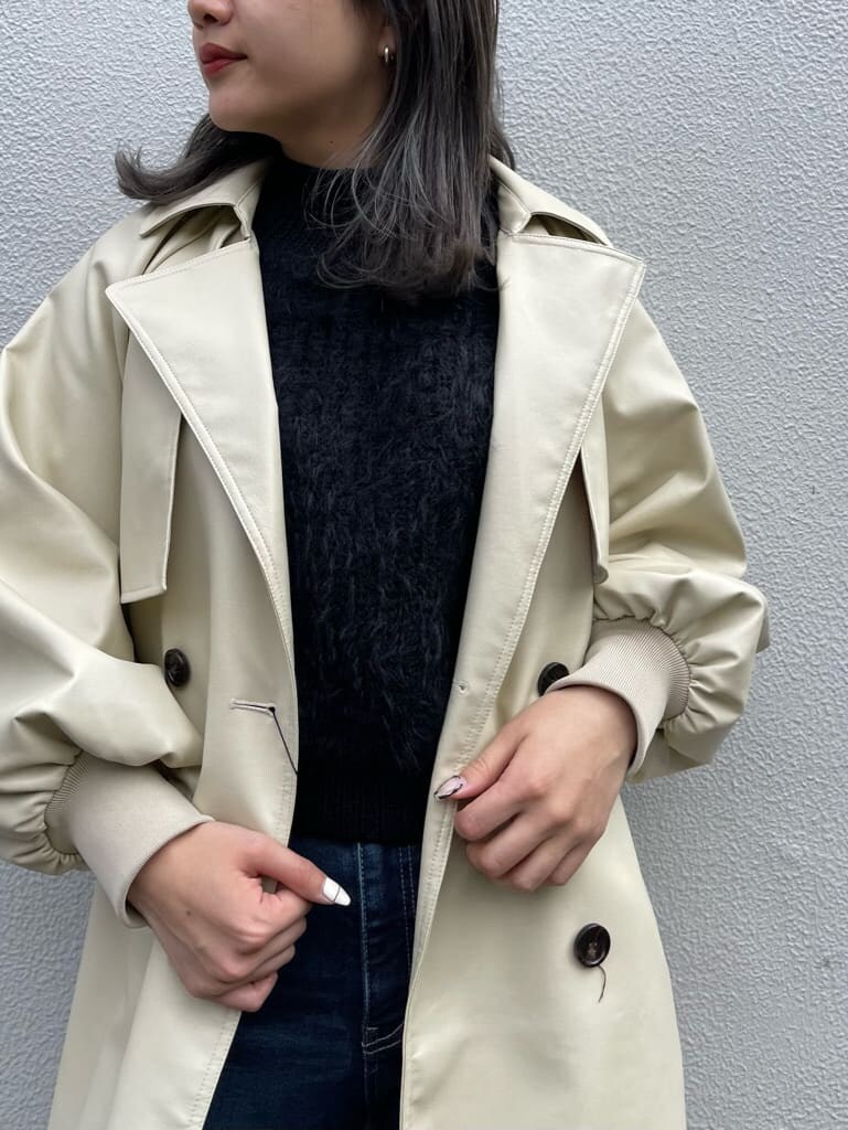 ブラック系のニット/セーター、ホワイト系のトレンチコート、ブラック系のブーツを着用したレディースの冬コーディネートの5枚目の写真