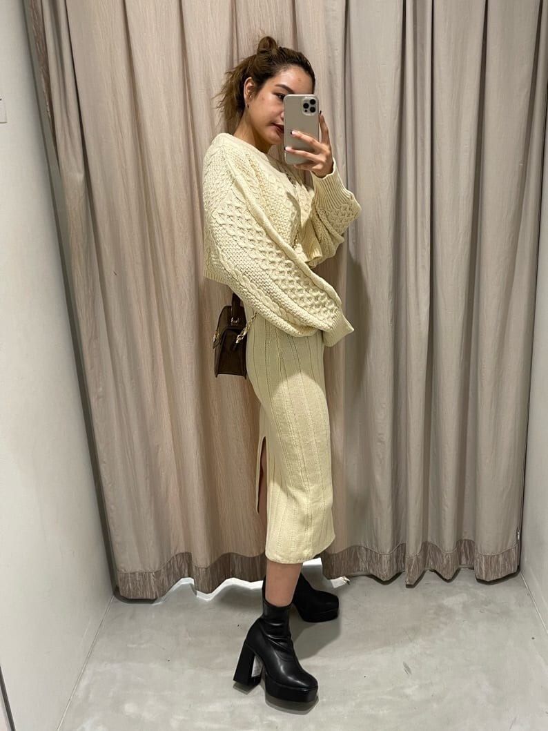 ブラック系のブーツ、ホワイト系のワンピース、ブラウン系のハンドバッグを着用したレディースの秋コーディネートの3枚目の写真