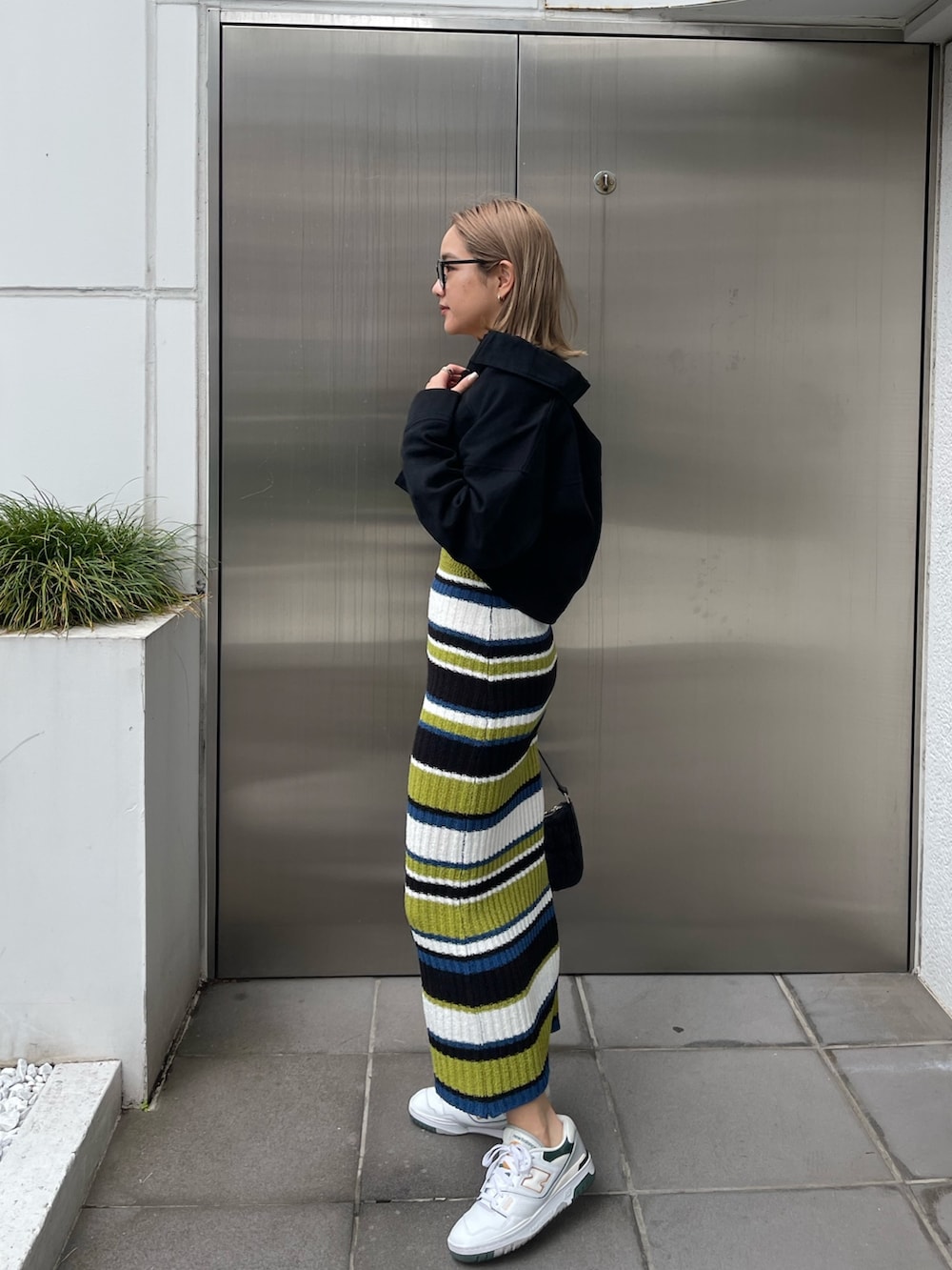 ブラック系のワンピース、ブラック系のミリタリージャケット、ブラック系のハンドバッグを着用したレディースの春コーディネートの4枚目の写真