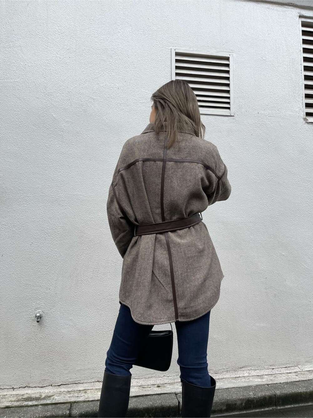 ブラック系のブーツ、ブルー系のデニムパンツ、ブラウン系のその他アウターを着用したレディースの秋コーディネートの4枚目の写真