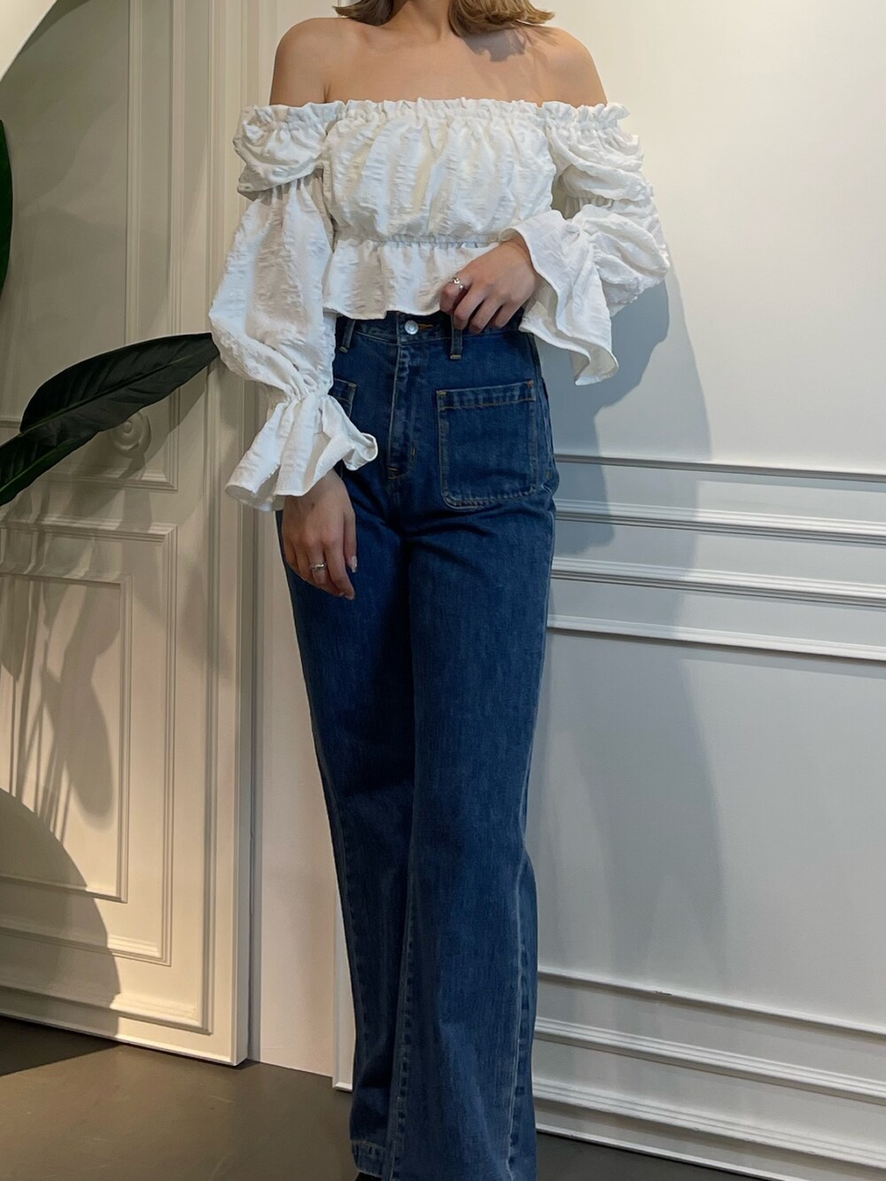 ブルー系のデニムパンツ、ホワイト系のシャツ/ブラウス、ブラック系のスニーカーを着用したレディースの春コーディネートの3枚目の写真