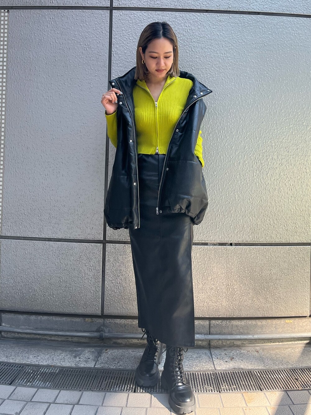 ブラック系のブルゾン、ブラック系のスカート、ブラック系のブーツを着用したレディースの秋コーディネートの3枚目の写真