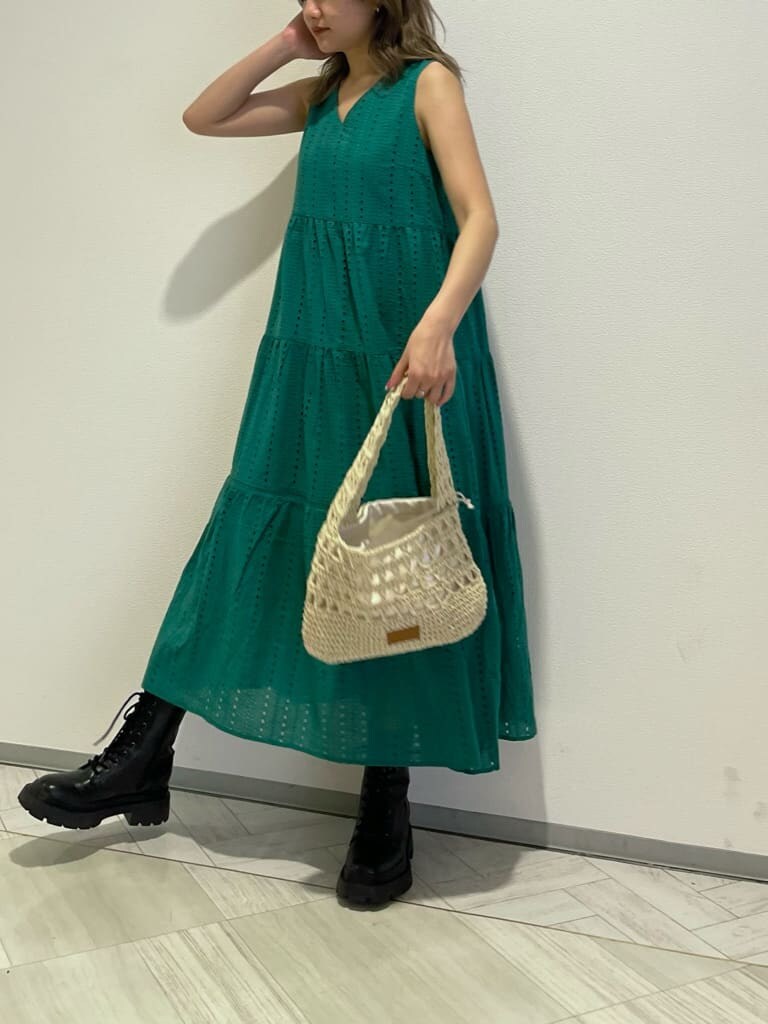 ブラック系のブーツ、グリーン系のワンピース、ベージュ系のショルダーバッグを着用したレディースの春コーディネートの2枚目の写真