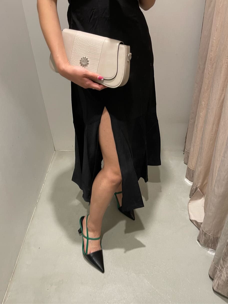 ブラック系のサンダル、ブラック系のワンピース、ホワイト系のショルダーバッグを着用したレディースの春コーディネートの4枚目の写真