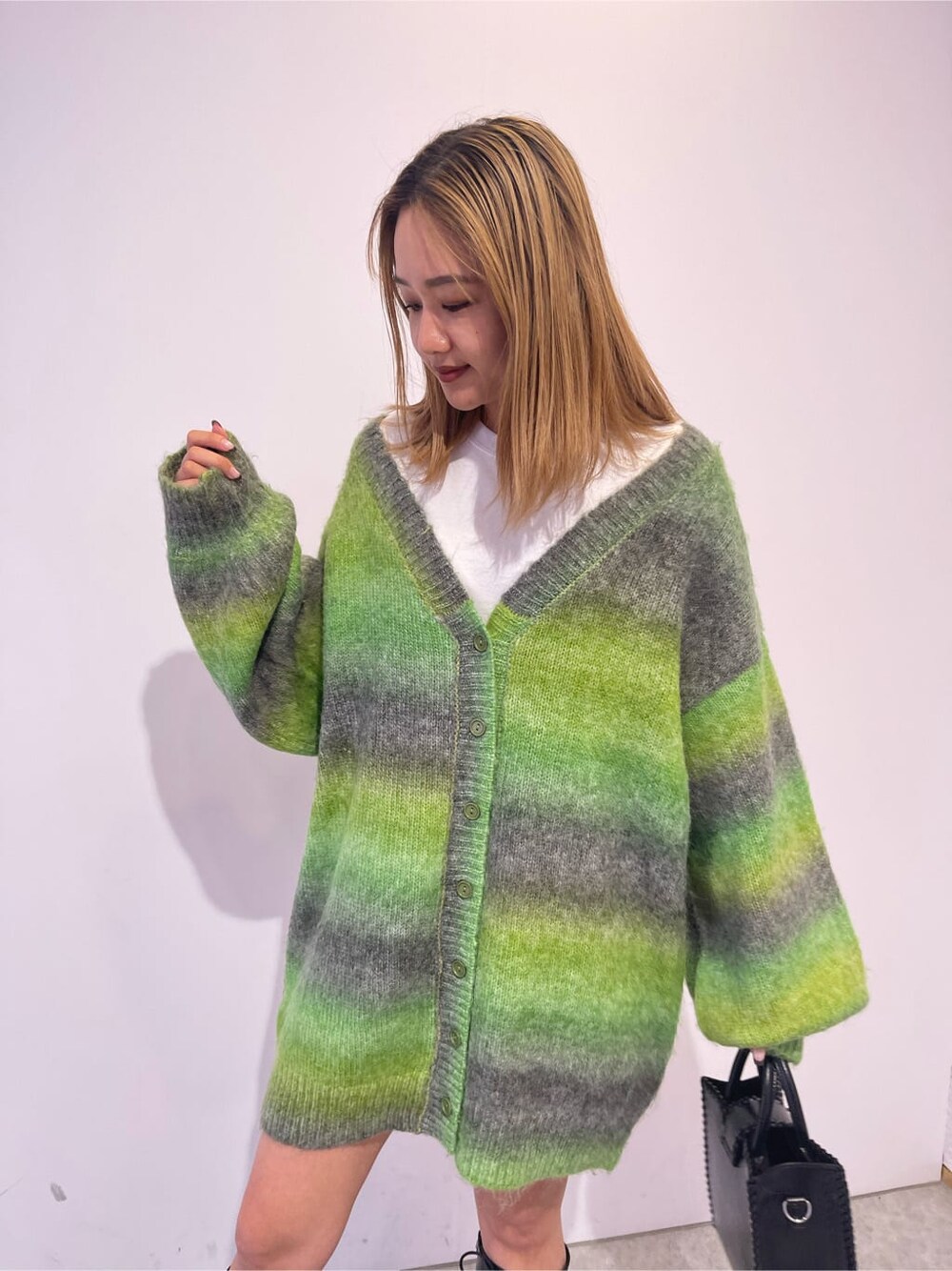 ブラック系のブーツ、ブラック系のショルダーバッグ、グリーン系のカーディガン/ボレロを着用したレディースの秋コーディネートの5枚目の写真